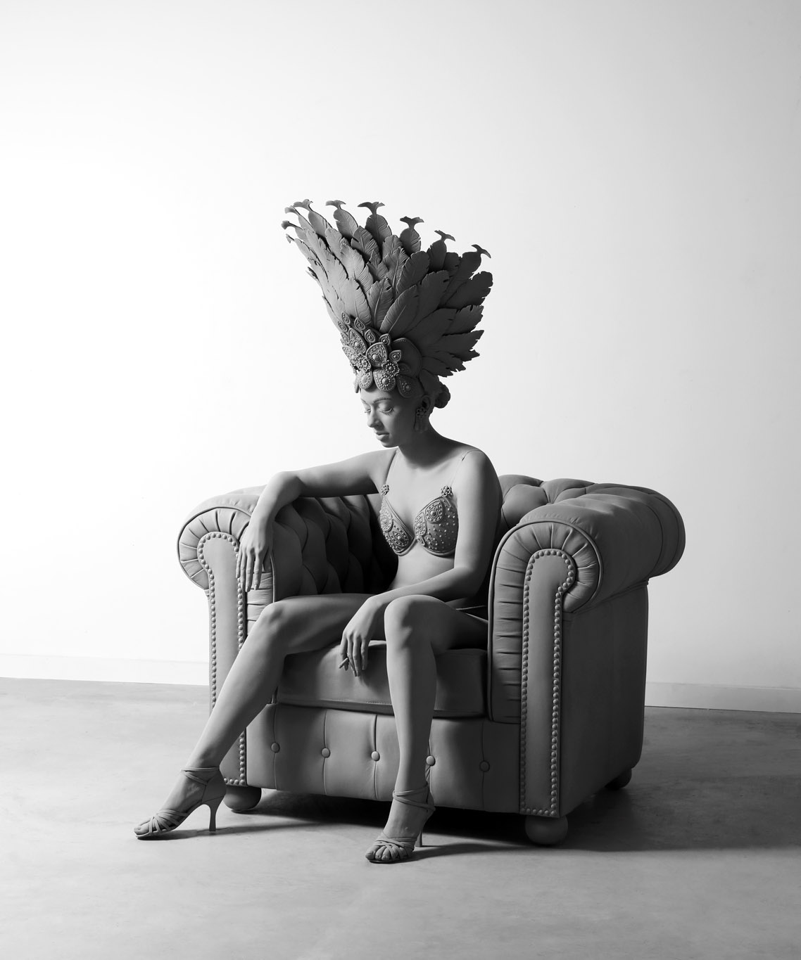 Hans Op d Beeck, Dancer, sculpture grise en polyester d'une danseuse brésilienne avec chapeau de plumes, assise dans un fauteuil Chesterfield, exposition Silence & Résonance, Musée de Flandre, Cassel, France, Boombartstic Art Magazine