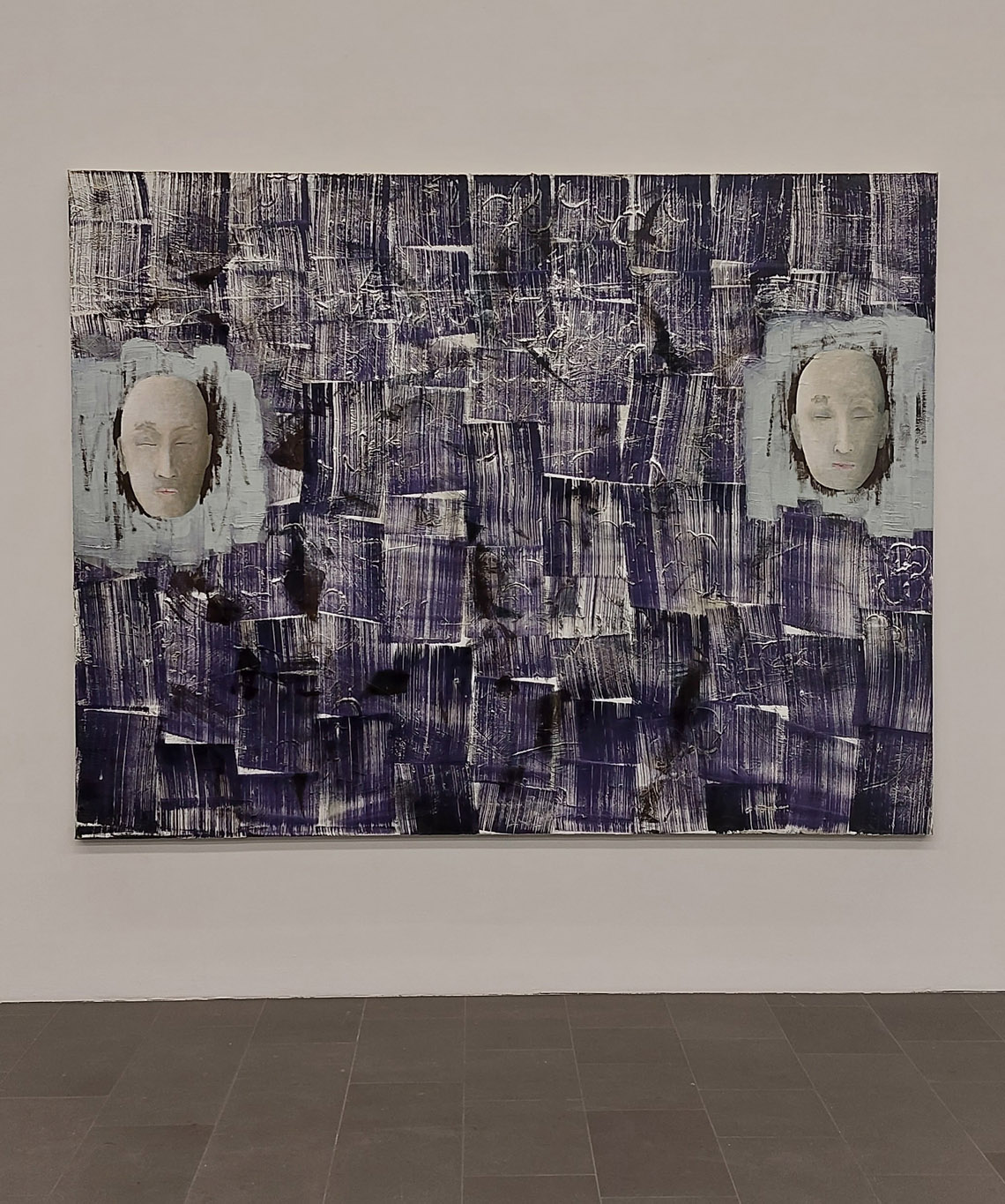 Christoph M. Gais, huile sur toile aux deux visages sur fond aux motifs rectangulaires bleu encre brossés, vue de l'exposition Image Worlds from 1990 until Today, 2023, MKM Museum Küppersmühle für Moderne Kunst, Duisburg, Allemagne, (c) Christoph M. Gais, (c) photo Eric Mabille, Boombartstic Art Magazine